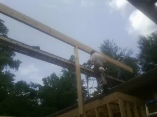 Carpenter setting a ridge beam over a new addition frame — Ice Dam Removal by Roofing Brothers in Seth