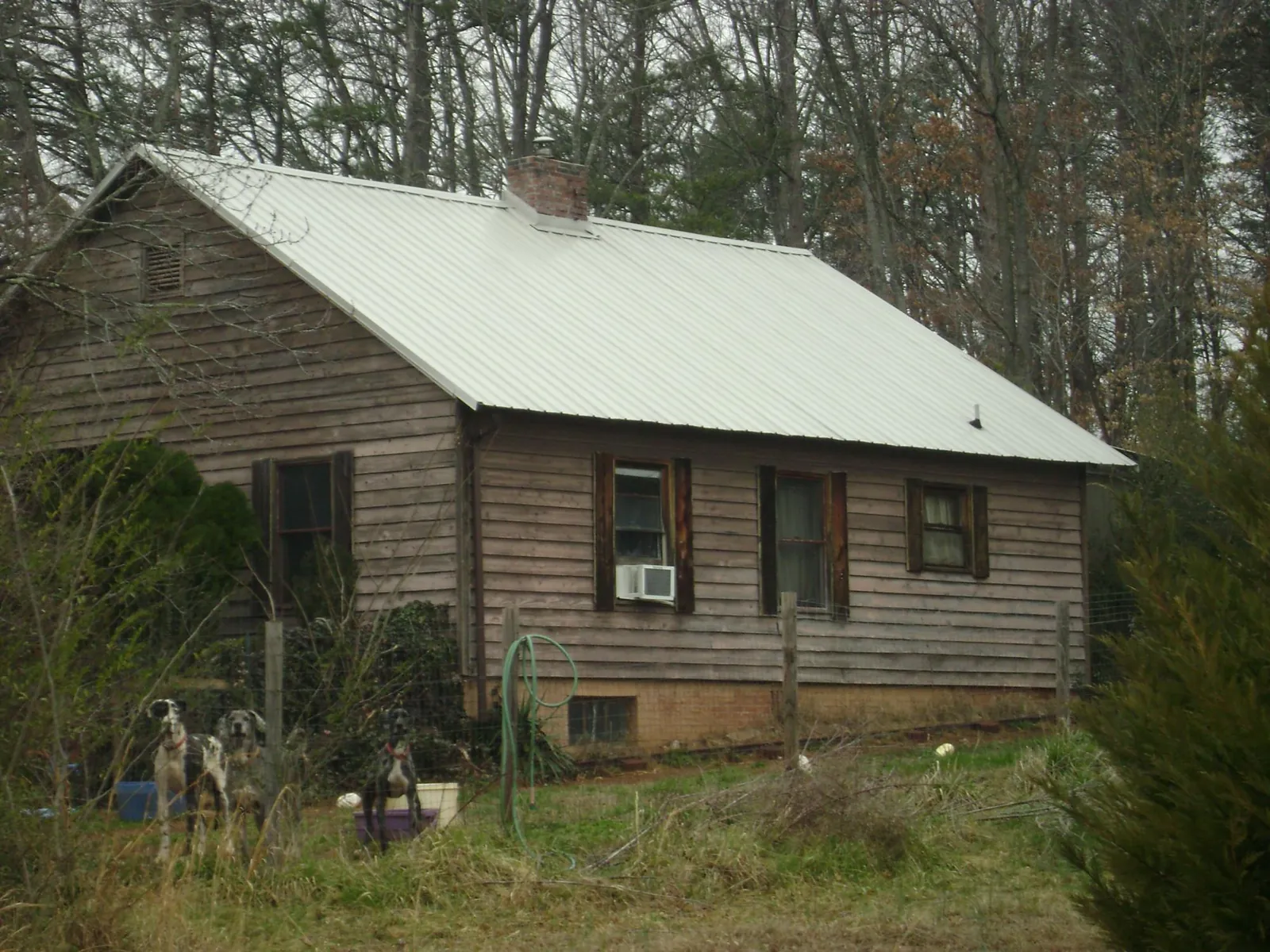 White metal roof on an old wood sided farmhouse, from a Metal Roof Installation job in Seth